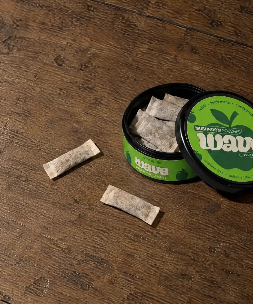Een geopend WAVE-blikje met pouches erin en twee losse pouches ernaast.